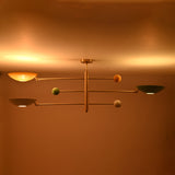 Modern brass flush mount ceiling fixture creating soft evening illumination with multicolor bowl shades