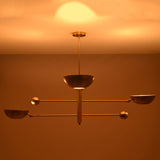 Modern brass ceiling chandelier casting soft indirect glow across the ceiling