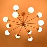 Modern brass chandelier with glowing opal globes creating dramatic evening ambience