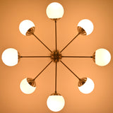 Modern brass chandelier with glowing opal globes creating soft evening ambience