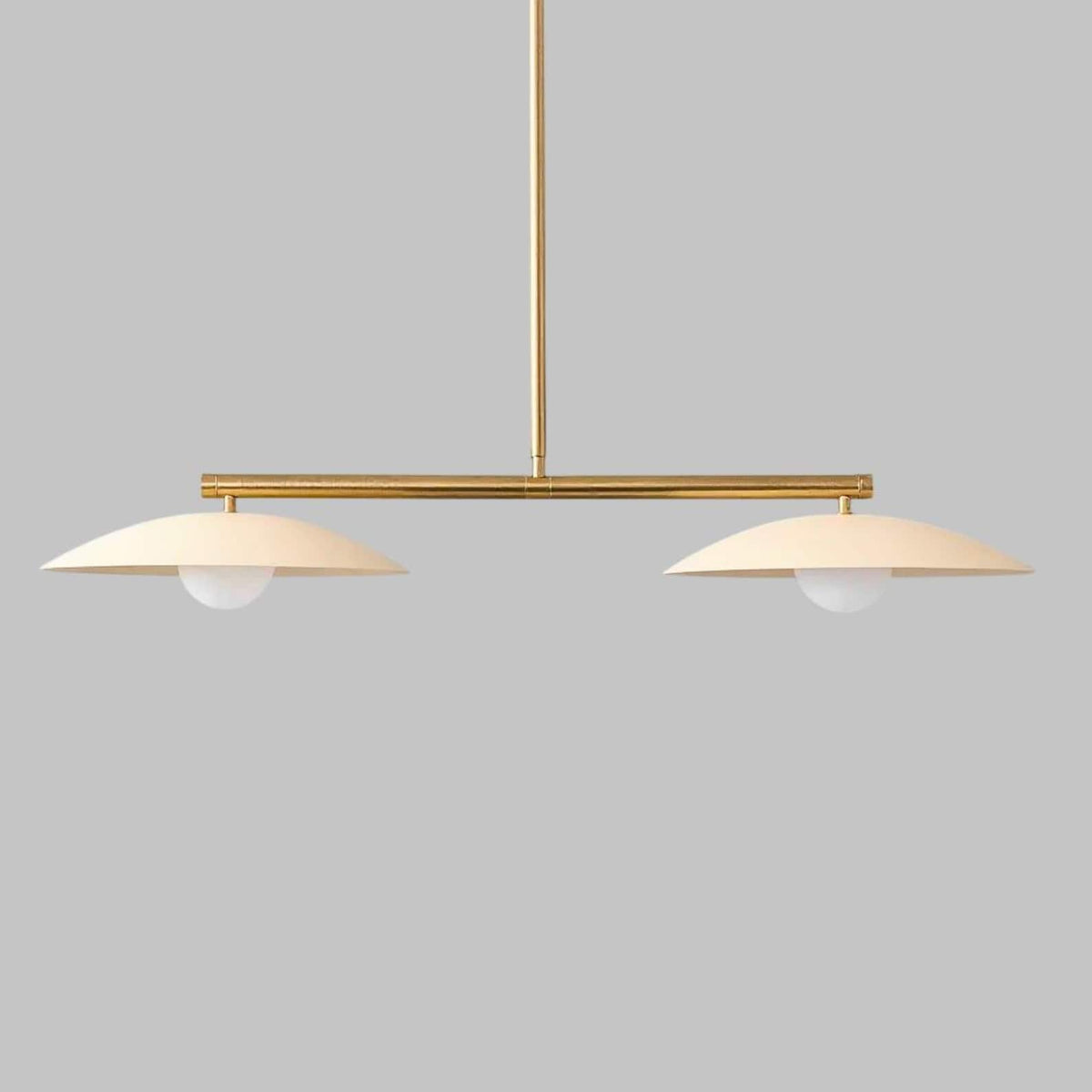 Modern brass disc chandelier featuring twin glass globes and clean horizontal silhouette