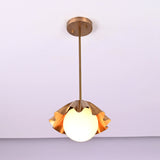 Front view of handcrafted brass disc pendant light with fluted shade and soft warm glow.