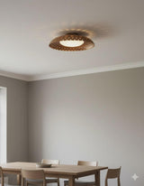 Minimal interior featuring a modern brass flush mount ceiling light with warm indirect glow and sculpted bowl form