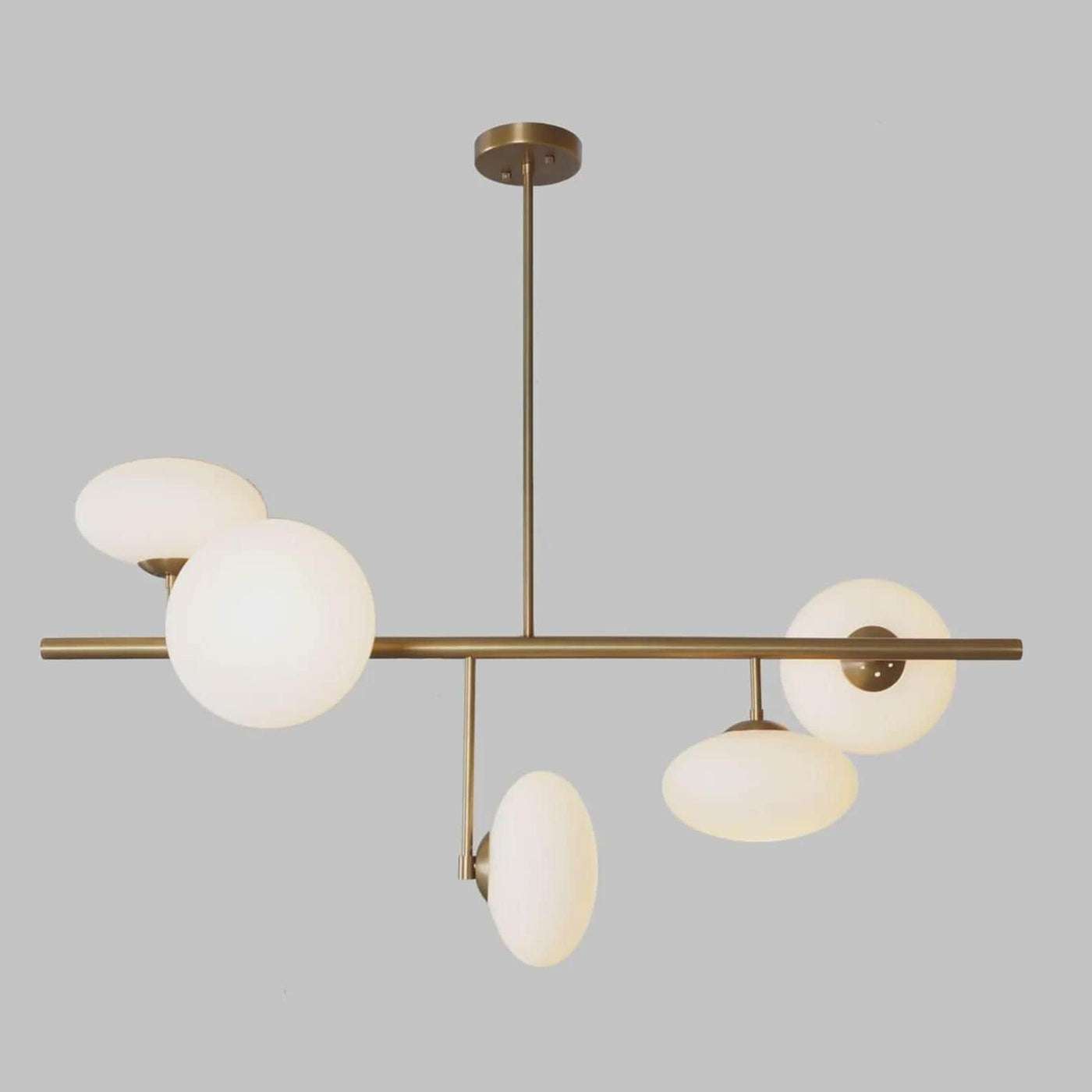 Front view of a modern brass globe chandelier with five lights, designed for dining rooms and living spaces with warm ambient illumination.