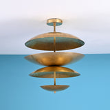 Sculptural layered brass ceiling light featuring bowl-shaped disc shades in a modern industrial flush mount design.