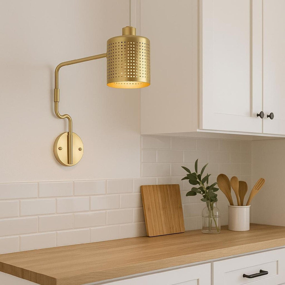Modern brass wall light with adjustable arm installed above kitchen countertop backsplash