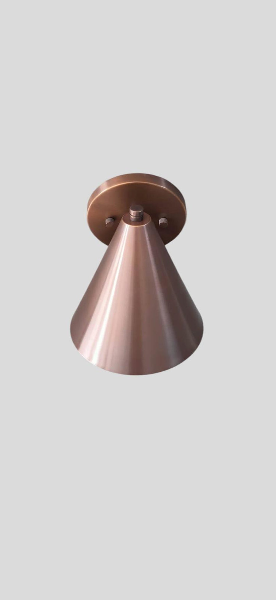 Handcrafted brushed copper cone wall light with minimalist design and warm metallic finish by Brass Leaf Studio.