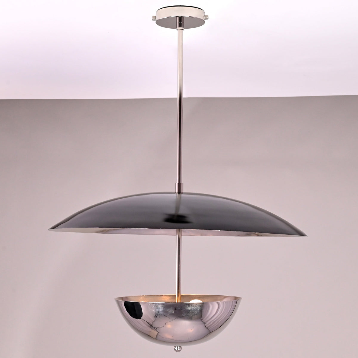 Side view of modern chrome brass chandelier with sculpted disc and bowl-shaped brass form