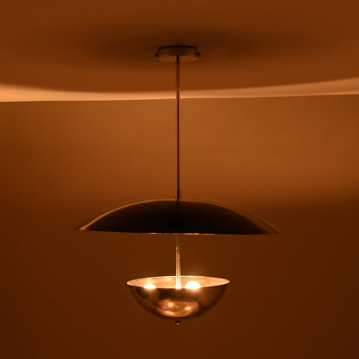 Modern chrome brass chandelier showcasing warm lighting effect with reflective polished surfaces
