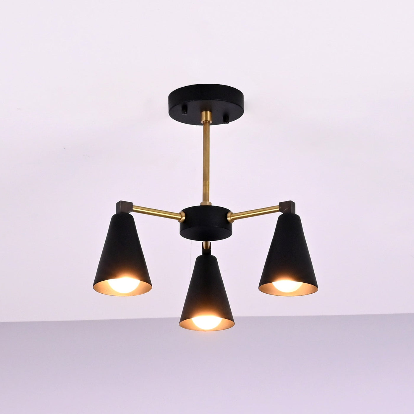 Angled view of modern cone brass ceiling light with balanced three arm configuration