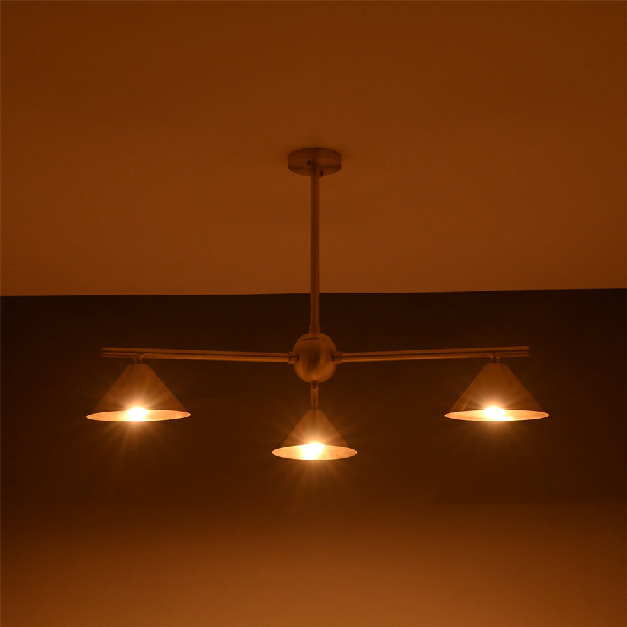 Modern solid brass chandelier with three cone-shaped shades, brushed finish, handcrafted for contemporary interior lighting.