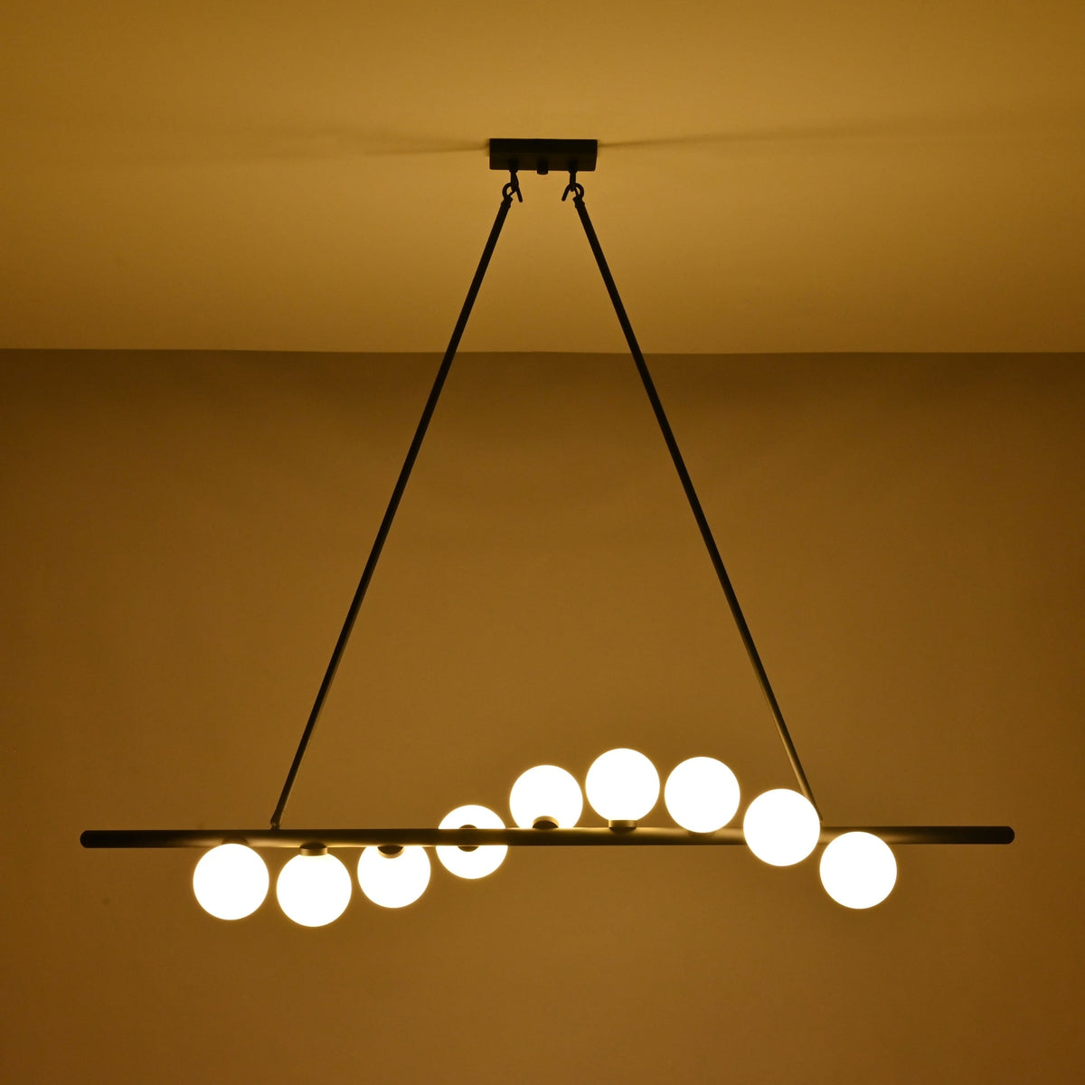 Modern dining room globe chandelier suspended above a wooden table with soft warm lighting and elegant décor