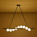 Modern dining room globe chandelier suspended above a wooden table with soft warm lighting and elegant décor