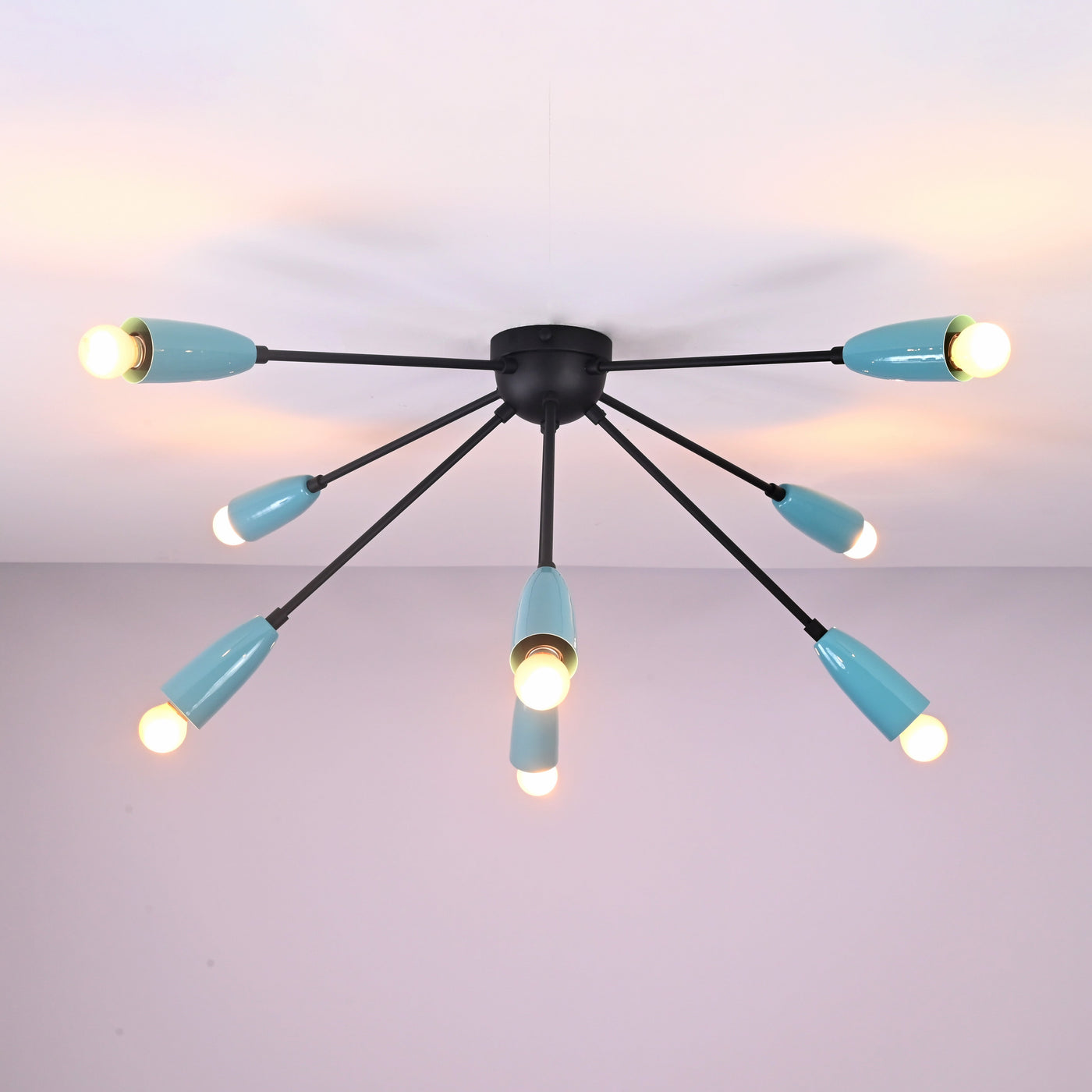 Modern orbit-style 8-light brass flush mount chandelier illuminated with warm ambient lighting