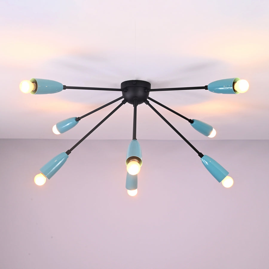 Modern orbit-style 8-light brass flush mount chandelier illuminated with warm ambient lighting