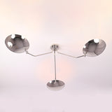 Bottom view of modern polished chrome ceiling light with three symmetrical brass bowl shades.