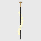 Modern stairwell globe chandelier shown from side angle with staggered round shades and tall vertical profile