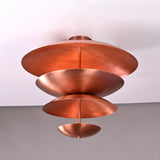 Bottom-angle shot of the modern tiered brass flushmount chandelier showcasing its sculptural bowl geometry and polished copper finish.