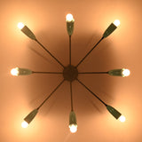 Orbit-style brass flush mount chandelier casting warm ambient light across the ceiling