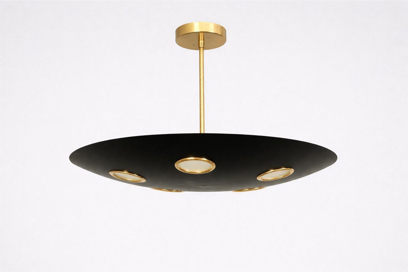 Orbit disc brass chandelier in matte black with gold accents, featuring five recessed lights for warm ambient ceiling illumination.