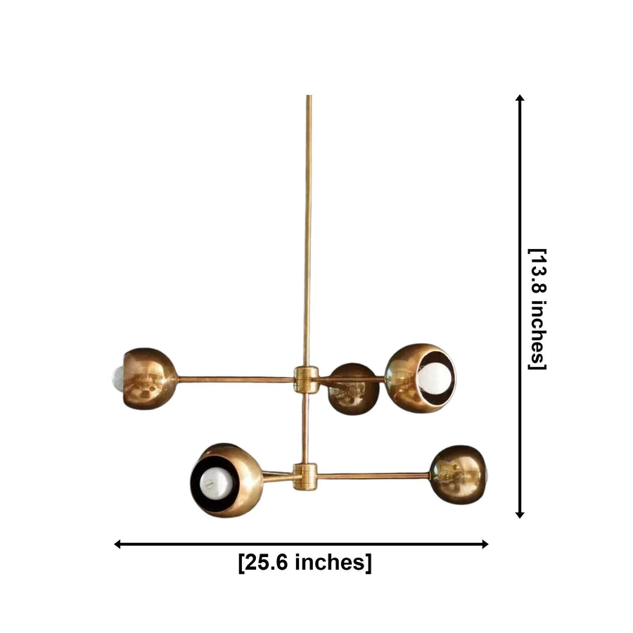 Orion Orbit 6 Light Brass Globe Chandelier illuminated above a modern dining table – lifestyle view
