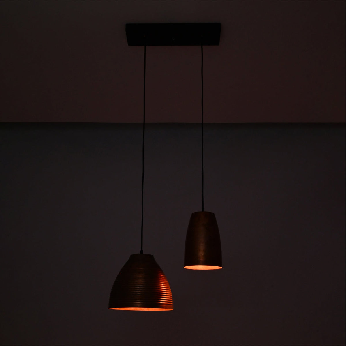 Oslo Modern Dual Copper Pendant Chandelier glowing with warm ambient light in a dark setting