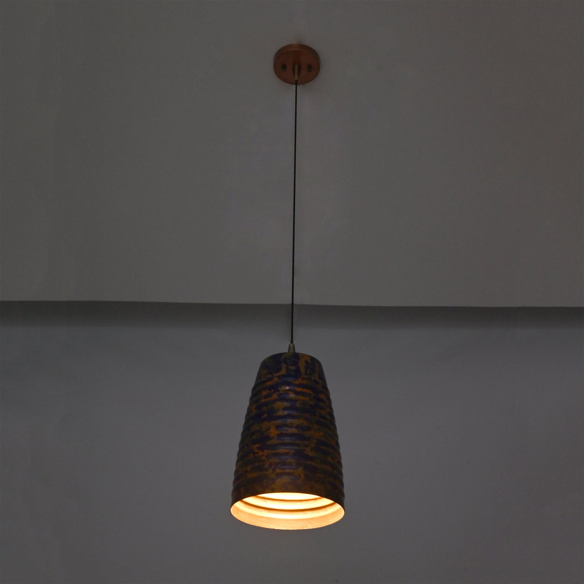 Patina cylinder pendant light closeup highlighting the ribbed shade texture and decorative blue copper finish