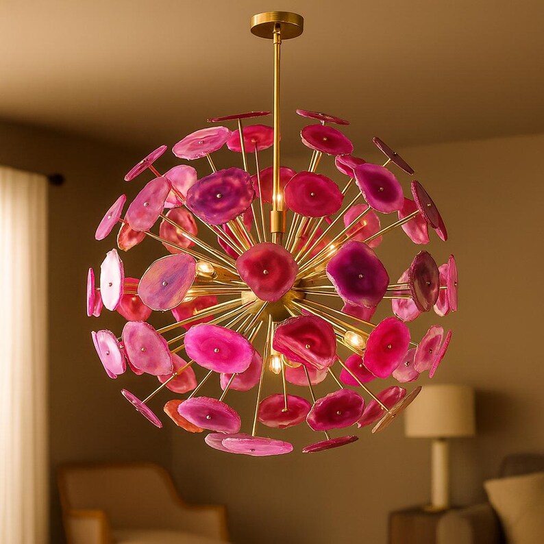 Pink agate stone chandelier with brushed brass frame glowing warmly in an elegant interior setting