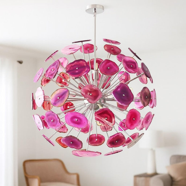 Pink agate stone chandelier with brushed brass frame glowing warmly in an elegant interior setting