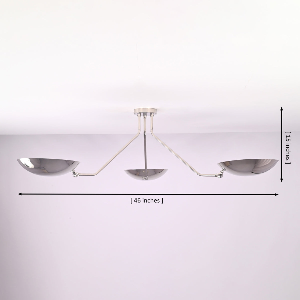 Modern polished chrome ceiling light showing 46 inch width and 15 inch height with three bowl shaped brass shades.