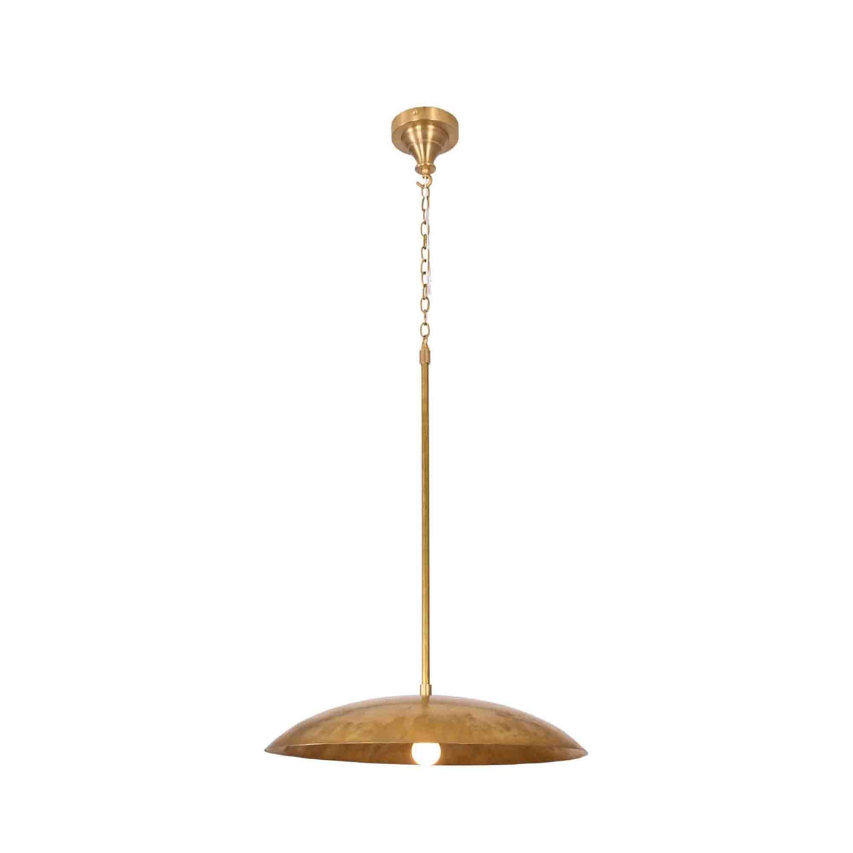 Raw brass dome pendant light closeup showing wide curved shade, chain suspension, and warm glowing bulb detail