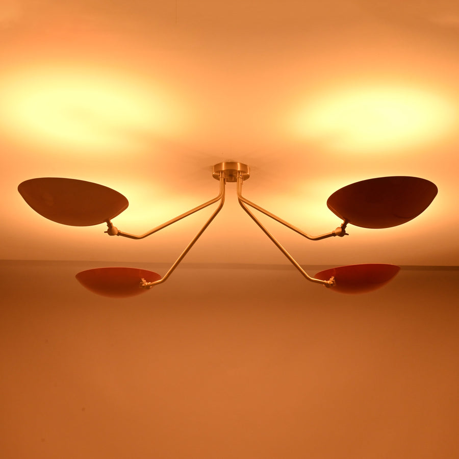 Angled view of modern red disc chandelier highlighting solid brass craftsmanship and minimalist industrial design.