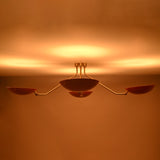 Flush mount red disc chandelier producing soft ambient glow with bowl shaped shades and premium brass construction.