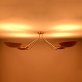 Top view of red disc flush mount ceiling light when lit, showcasing soft uplighting and balanced four light configuration.