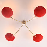 Top view of modern red disc flush mount chandelier featuring four bowl shades and sculpted solid brass arms in symmetrical layout.