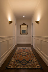 Ruffled bowl wall sconce in brass finish with curved scalloped edges and elegant sculptural form