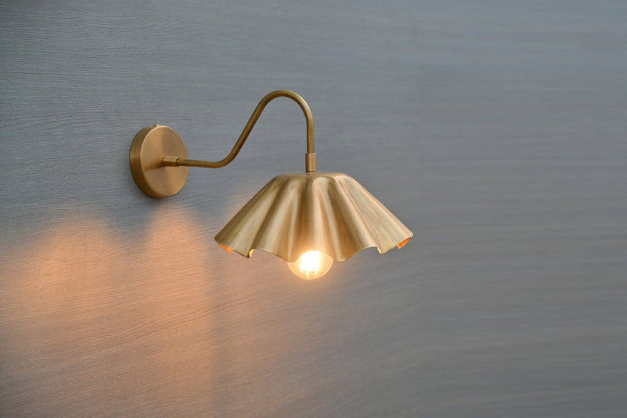 Handmade scalloped brass wall sconce with fluted shade and curved arm – side angle view