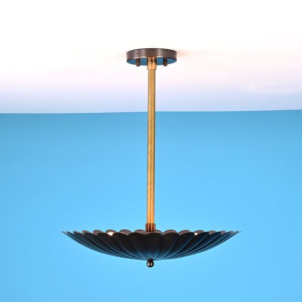 Side angle view of handcrafted scalloped brass pendant light with pleated disc shade
