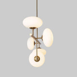 Vertical view of a sculptural brass chandelier with milky glass discs, highlighting modern geometry and soft diffused lighting.