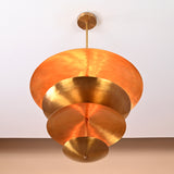 Bottom view of sculptural layered brass chandelier showcasing artistic disc arrangement and warm reflective surfaces.