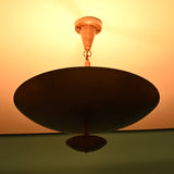 Solid brass bowl chandelier emitting warm indirect light with a refined modern silhouette and atmospheric ceiling illumination