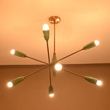 Warm-lit 8-light Sputnik chandelier in teal and brushed brass, creating soft ambient glow with mid-century cone shades.