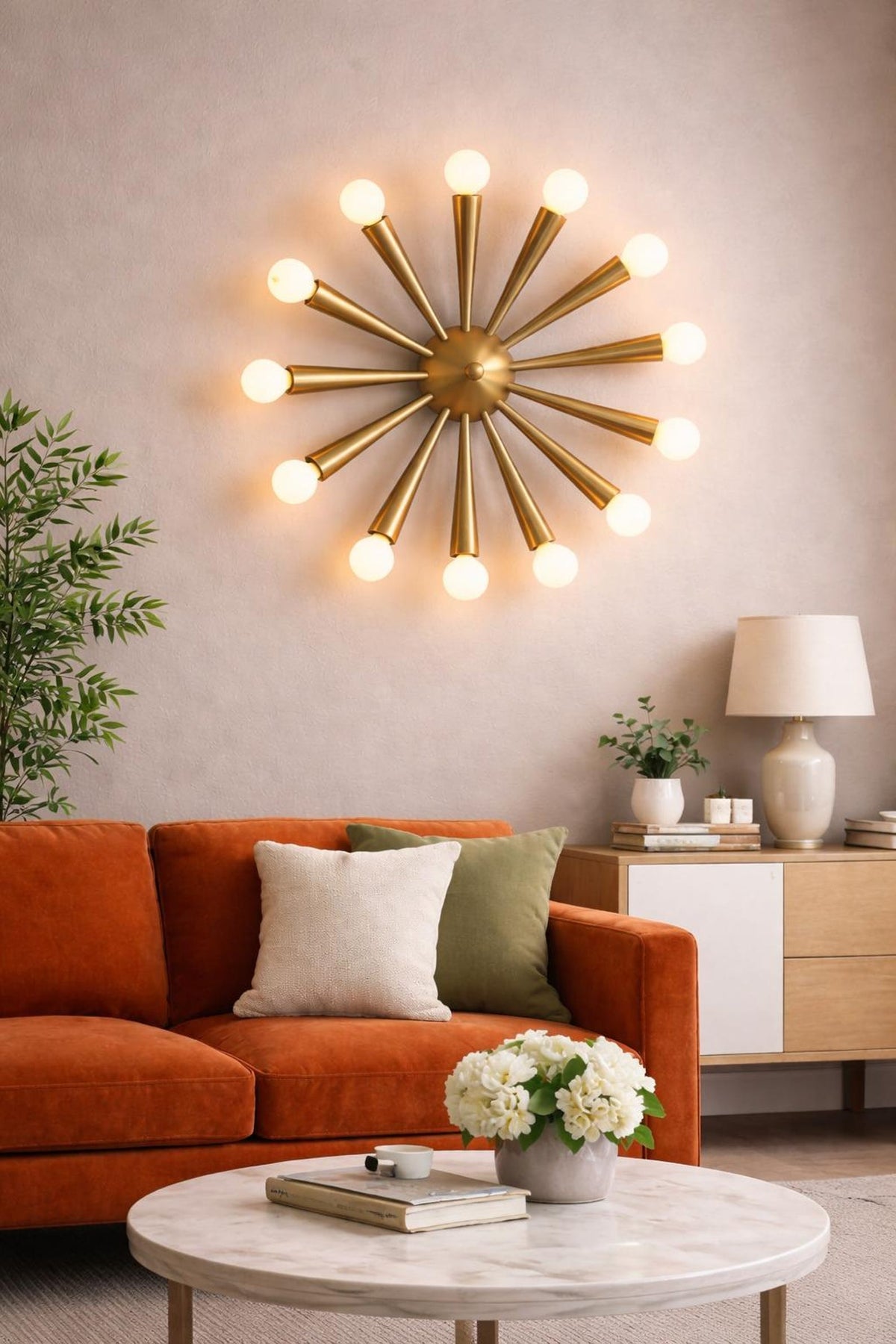 Handcrafted brass starburst wall light illuminating a modern living room, featuring a 12-light mid-century inspired radial design.