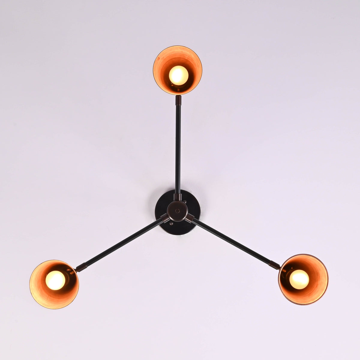 Bottom view of three light copper cone chandelier highlighting symmetrical modern design