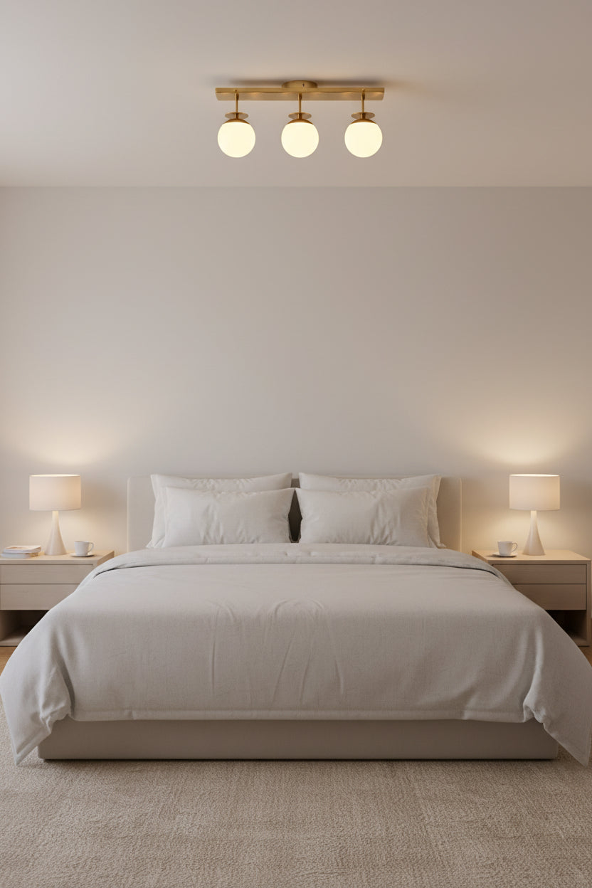 Modern brass 3-globe ceiling light with rectangular canopy, short stems, and soft ambient illumination