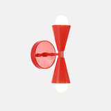 Vera Red solid brass double cone wall sconce shown illuminated with warm upward and downward glow