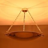 Brass chain chandelier emitting soft warm lighting with wide reflector bowl design
