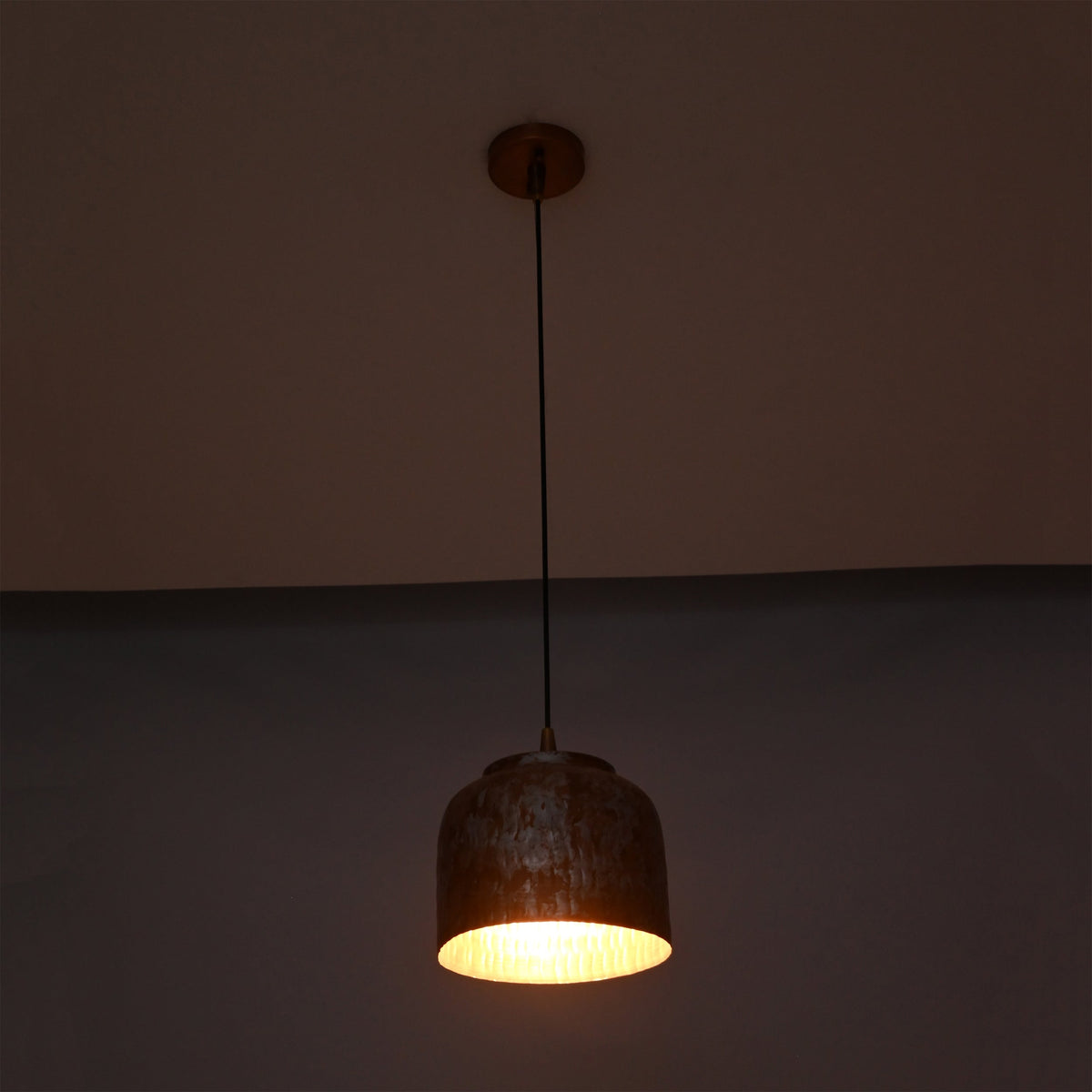 Whitewashed copper pendant light shown from front with compact rounded drum shade and warm interior glow